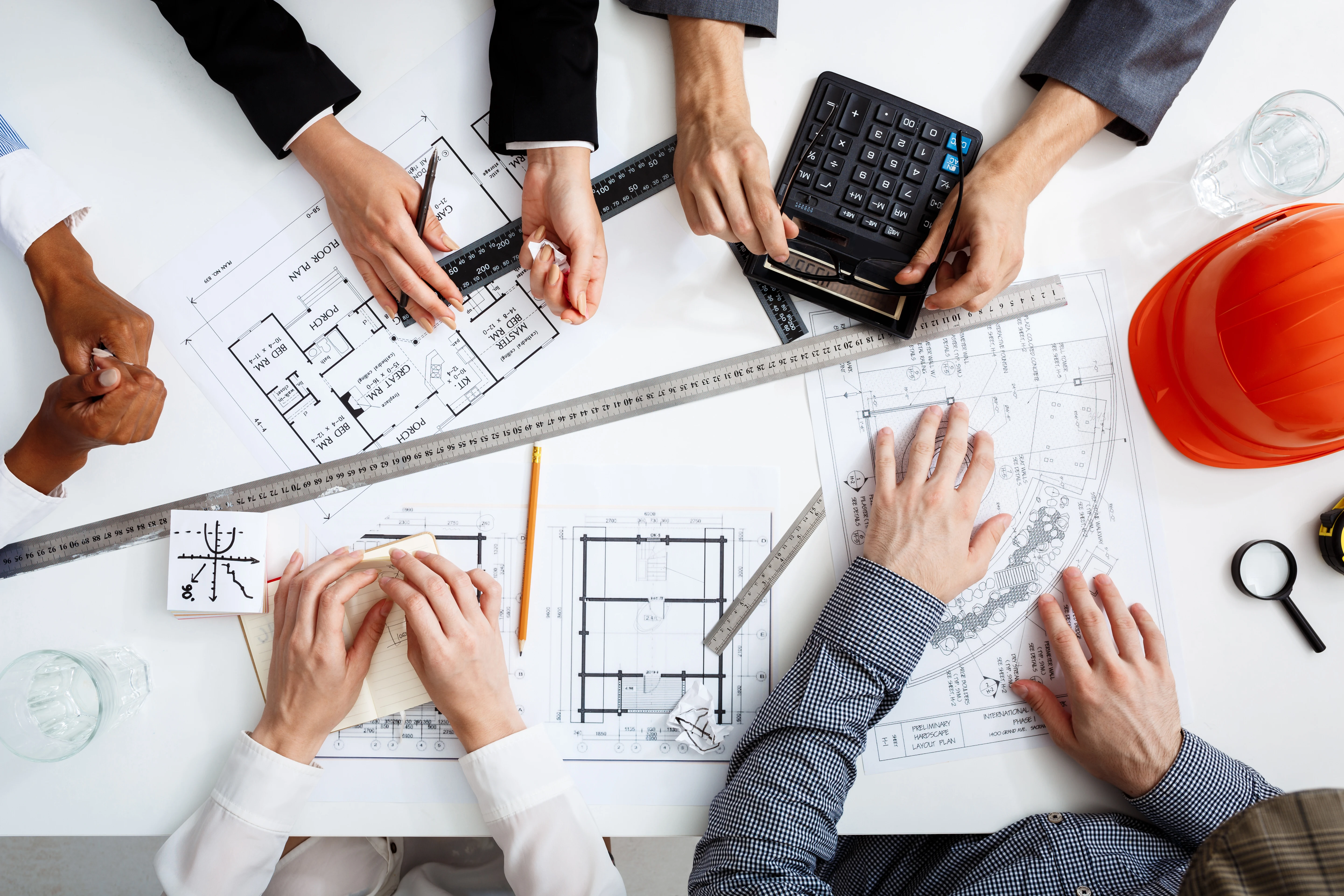 Equipo multidisciplinario revisando planos y costos de un edificio